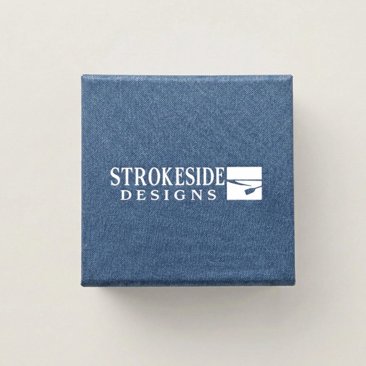 A blue box with the Strokeside Designs logo printed on it.